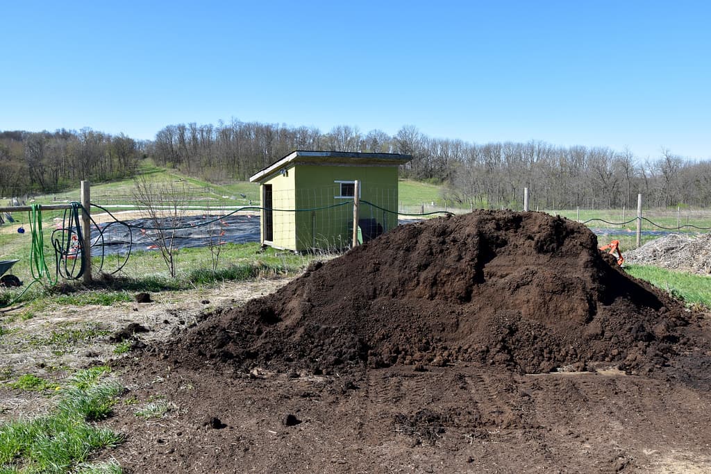 A freshly-delivered pile of dark, finished compost ready to be spread on garden beds